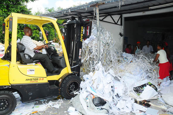 Forklift unloading truck and pushing the waste paper to facilitate segregation of different grades of paper